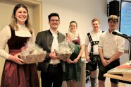 Fünf Menschen, von denen zwei einen Geschenkkorb in den Händen halten