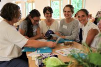 Fünf Frauen sitzen an einem Tisch und spielen ein Spiel