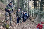 Eine Gruppe Menschen an einem steilen Berghang im Wald