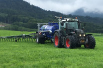 Traktor mit Güllefass auf einer Wiese